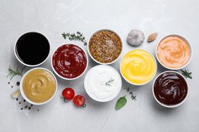 Many different condiments on a white table