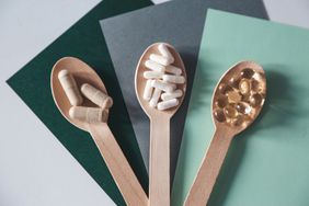 Three spoons with vitamins and supplements on a table