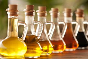 Vinegars in glass bottles aligned on a wooden table
