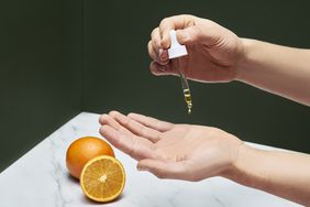 A person pouring vitamin c serum onto their hand
