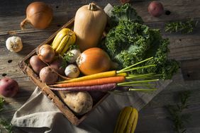 A box of winter vegetables like potatoes, garlic, squash, kale, etc. 