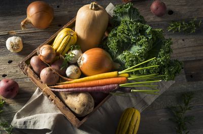 A box of winter vegetables like potatoes, garlic, squash, kale, etc. 