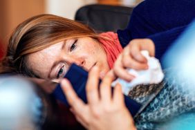 Woman looking at cellphone in bed