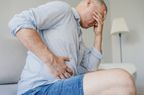 Man holding right side of stomach (near liver) in pain
