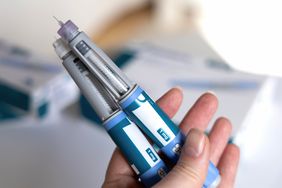 person holding ozempic and wegovy injection pens