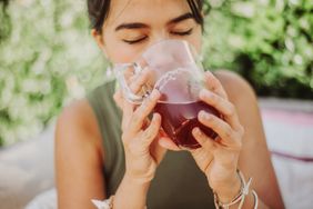 Woman drinking prune juice outside