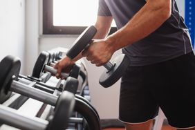 man picking up weights in gym