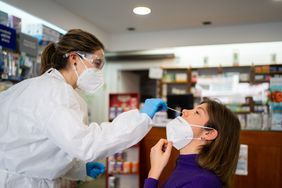 woman receiving covid test in pharmacy