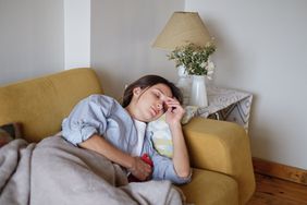 Woman lying on couch in pain.