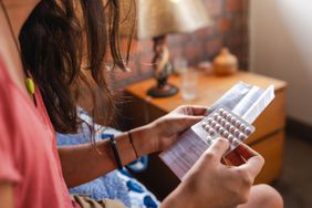 Woman reading birth control package