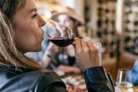 Woman drinking from glass of red wine.