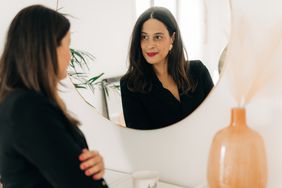 Beautiful multiracial woman looking at herself in the mirror