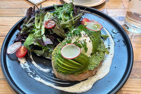 Sliced Avocado on toasted bread an salad, flat white