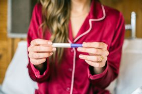 A woman looking at a pregnancy test