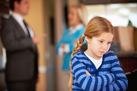 Upset child with parents int he background