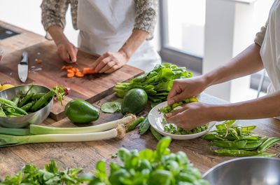 Series of lessons in a kitchen school where the chef teaching some contemporary food recipes. Women preparing vegetables cutting using knife. Only hands are visible.