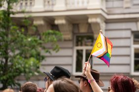 Many anonymous people marching at pride parade in the city.