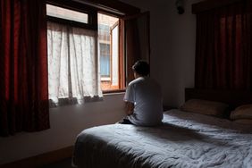 Unrecognizable man sitting in bed