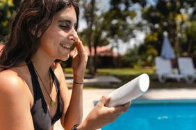 Woman putting on sunscreen