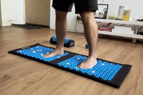 CXCTCT Extra-Long Yoga Acupressure Mat Set on floor with man's feet on top