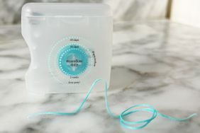 The Cocofloss Coconut-Oil Infused Woven Dental Floss and its packaging on a marble counter