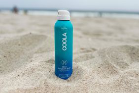 A bottle of Coola Organic Classic Sunscreen & Sunblock Spray in sand