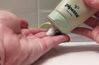 Hand squeezing Pipette eczema lotion onto fingertips