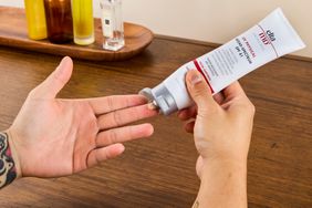 A person squeezes EltaMD UV Physical Broad-Spectrum SPF 41 Sunscreen onto their fingers