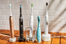 Assortment of the best electric toothbrushes we recommend on a wooden surface