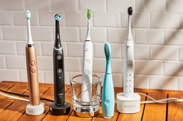 Assortment of the best electric toothbrushes we recommend on a wooden surface