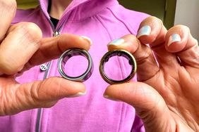 A person holds the Oura Ring 3 and Oura Ring 4 in their hands.