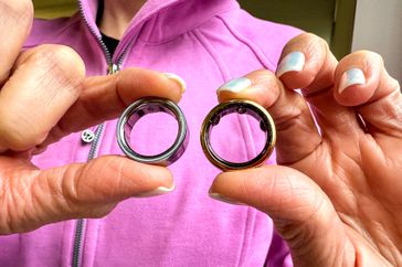 A person holds the Oura Ring 3 and Oura Ring 4 in their hands.