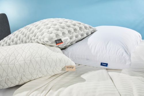 Three pillows we recommend for neck pain displayed on a bed