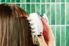 A person using a scalp massager