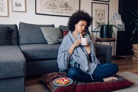 person drinking herbal tea to treat coughing