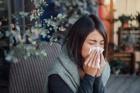 person with influenza a blowing nose