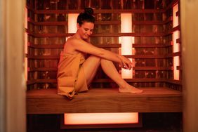 A woman sitting inside an infrared sauna
