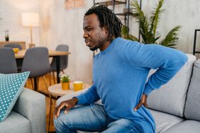 man putting his hand on his lower back