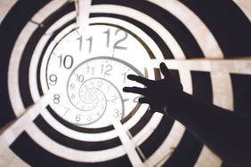 hand reaching towards light clock