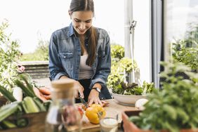 A woman chopping foods that are low-calorie and low-fat
