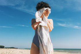 A woman towelling off on a beach