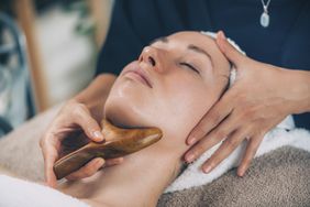A woman receiving a lymphatic drainage massage in the face