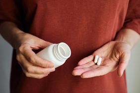 A woman pours pills of magnesium oxide into her hand