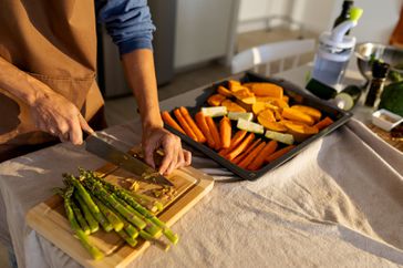 A man prepares vegetables at the counter to roast them