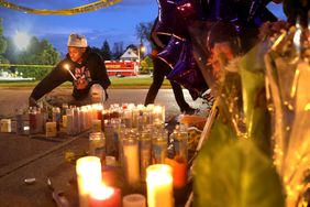 BUFFALO, NEW YORK - MAY 16: Mourners light candles at a makeshift memorial outside of Tops market on May 16, 2022 in Buffalo, New York. A gunman opened fire at the store yesterday killing ten people and wounding another three. The attack was believed to be motivated by racial hatred. (Photo by Scott Olson/Getty Images)