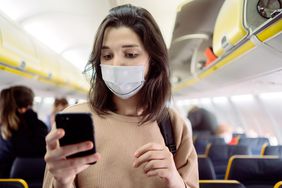 Woman With Mask On The Cabin Of A Plane.