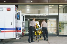 Paramedics taking patient on stretcher from ambulance to hospital