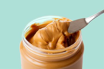 open jar of peanut butter with spoon