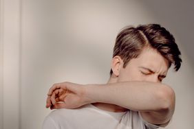 Man with lingering cough from COVID covering mouth with inside of elbow