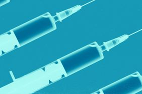 Four vaccine syringes against a blue background